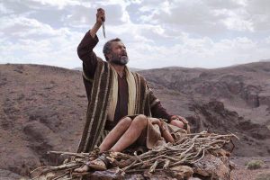 Abraham raises a knife above Isaac, who is bound on an altar of wood atop a mountain, symbolizing faith and obedience to God's command.