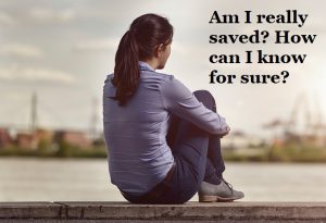 A woman sits alone on a ledge, gazing into the distance with a contemplative expression. The text overlay reads, "Am I really saved? How can I know for sure?"