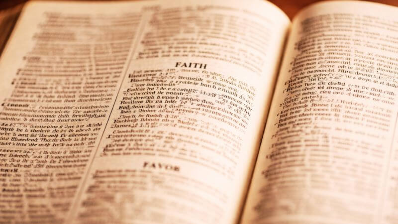 Close-up of a printed concordance showing alphabetical Bible word entries. 